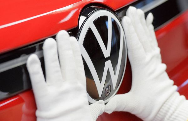 Kỹ thuật viên gắn logo Volkswagen lên ôtô tại dây chuyền sản xuất ở Zwickau, Đức, ngày 26/4/2022. Ảnh: Reuters